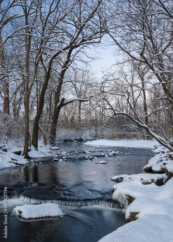 The colors of dusk settle over a secluded stream at the close of a winter day.