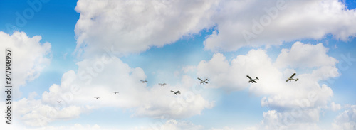 Panoramic view of coudy sky with  small airplanes