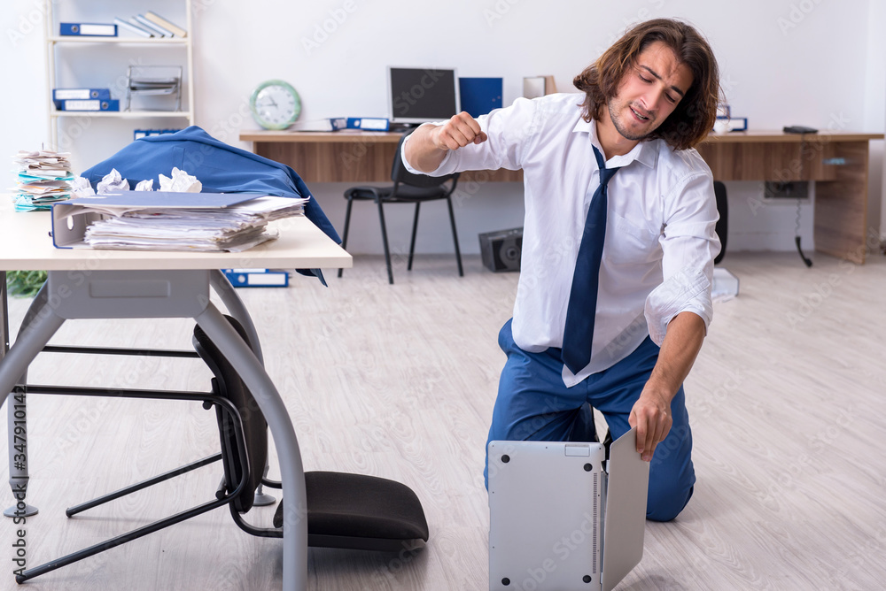 Fototapeta premium Young male employee unhappy with his work