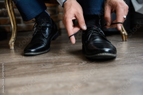man tying shoelaces on shoes