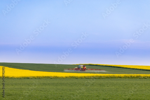 Traktor beim Düngen auf dem Feld