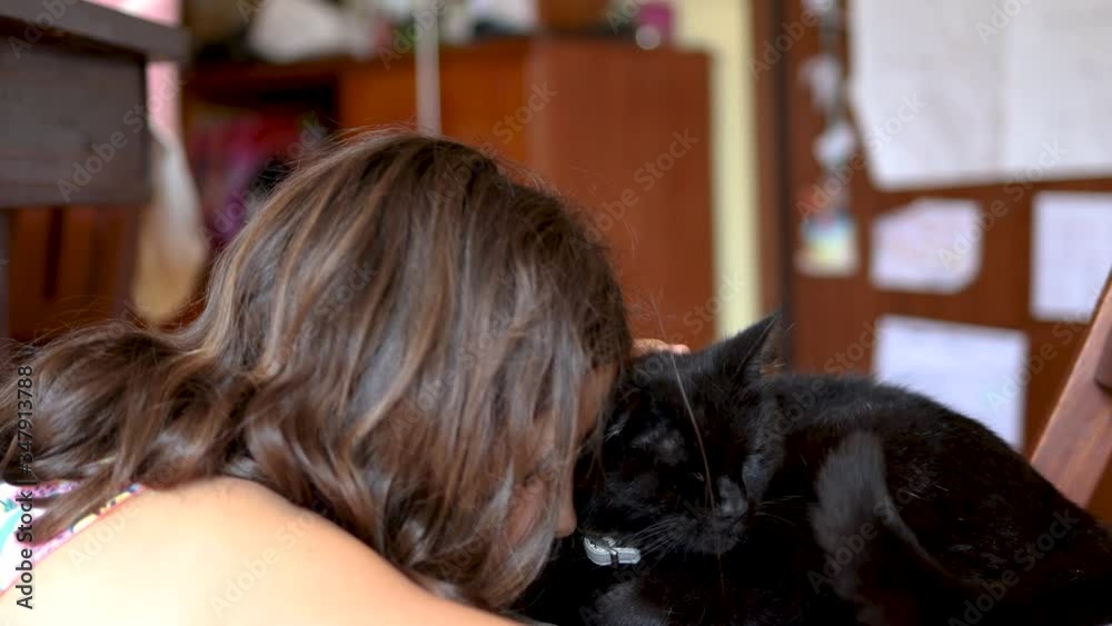 little girl playing cuddle her black cat little girl playing cuddle her black cat