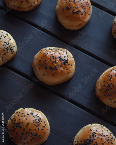 Freshly baked black sesame hamburger bun on wooden background