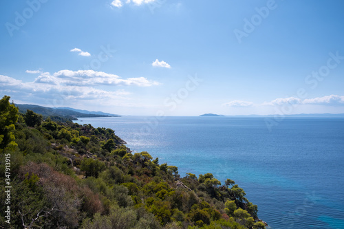 Colorful Landscape of Green hill with blue water and sky in the background