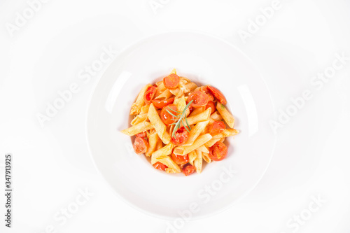 Penne with tomatoes, garlic and mozzarella decorated with rosemary twig, on a white background