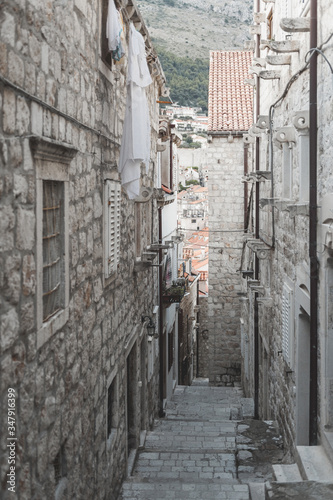 Fototapeta Naklejka Na Ścianę i Meble -  Small street in Dubrovnik in Croatia. Summertime, empty street with stairs. Early morning. Very atmospheric photo.