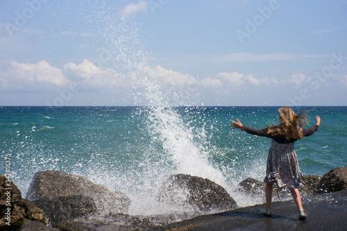 young girl playing on the beach in waves
