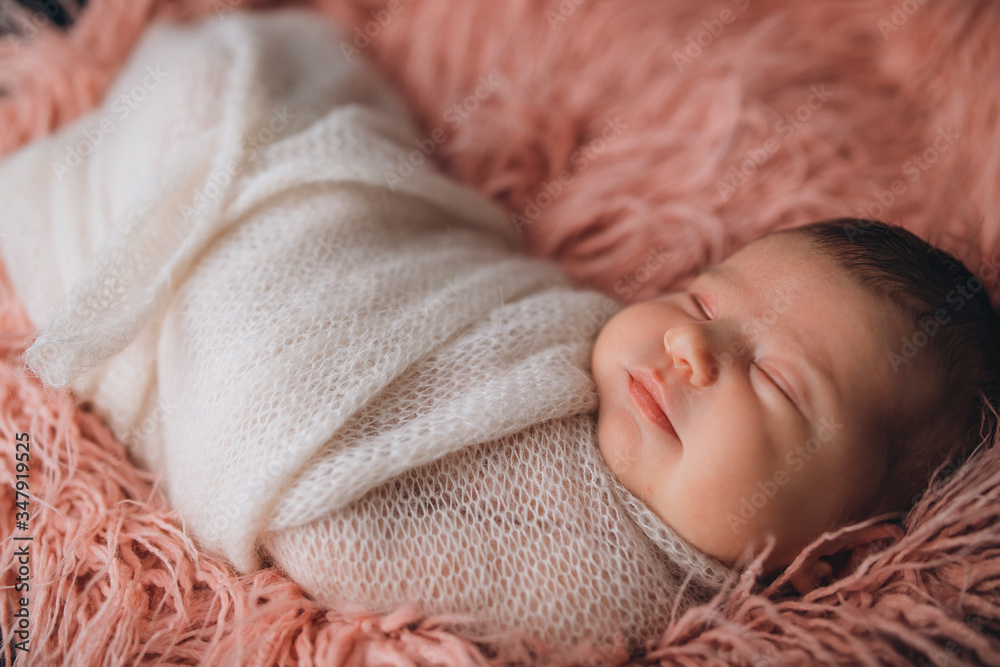 newborn baby in a cocoon sleeps cute on a pink tender bedspread newborn baby in a cocoon sleeps cute on a pink tender bedspread