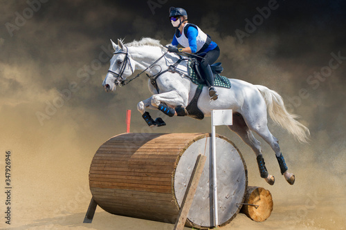 Eventing: equestrian rider jumping over an obstacle