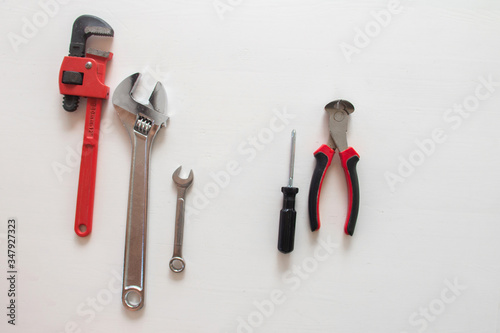Male tools. Happy Father's Day inscription with screwdriver, Mechanic hand hold spanner tool, pliers on white background. Greetings and presents. white card with the ability to insert text, copyspace