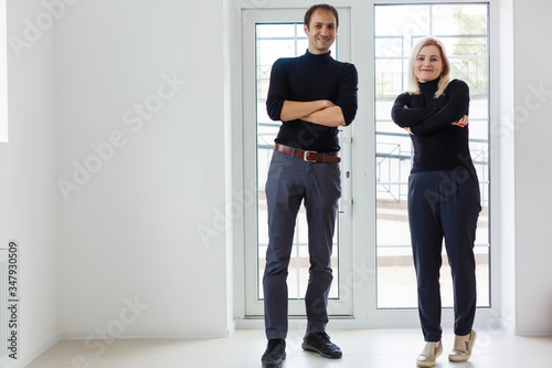 Portrait of confident male and female owners standing together in cafe