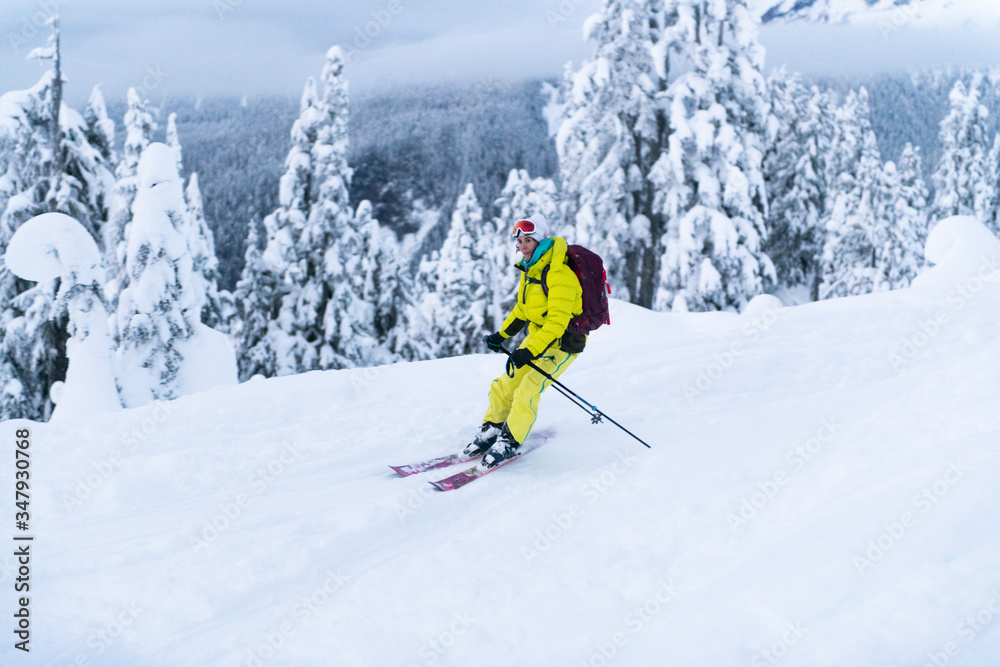 Woman in yellow backcountry skiing in Squamish, BC, Paul's Ridge Woman in yellow backcountry skiing in Squamish, BC, Paul's Ridge