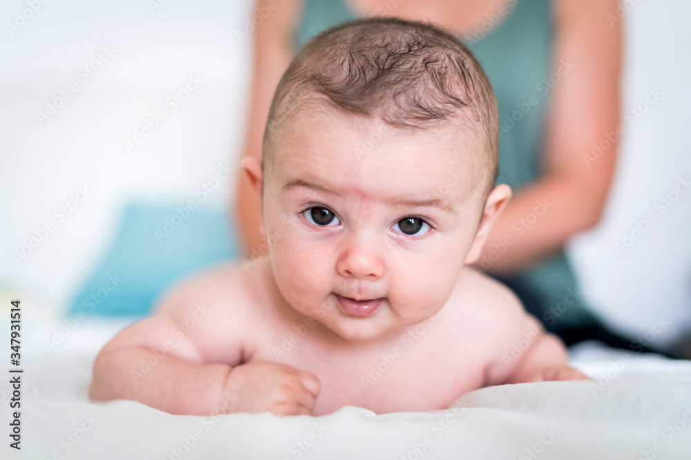 Close-up portrait of cute baby boy with brown eyes lying on bed Close-up portrait of cute baby boy with brown eyes lying on bed