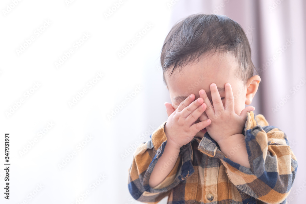 Asian baby boy playing hide and seek hiding face with parents,Concepts of learning development of child by playing. Asian baby boy playing hide and seek hiding face with parents,Concepts of learning development of child by playing.