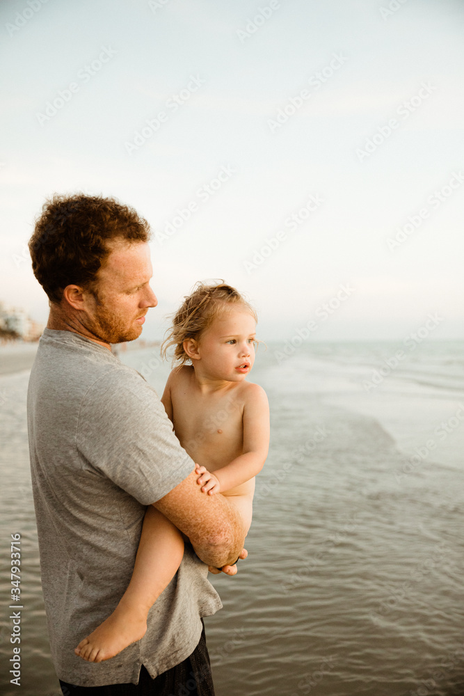 young dad holds an d looks at naked baby girl on vacation at beach Stock  Photo | Adobe Stock
