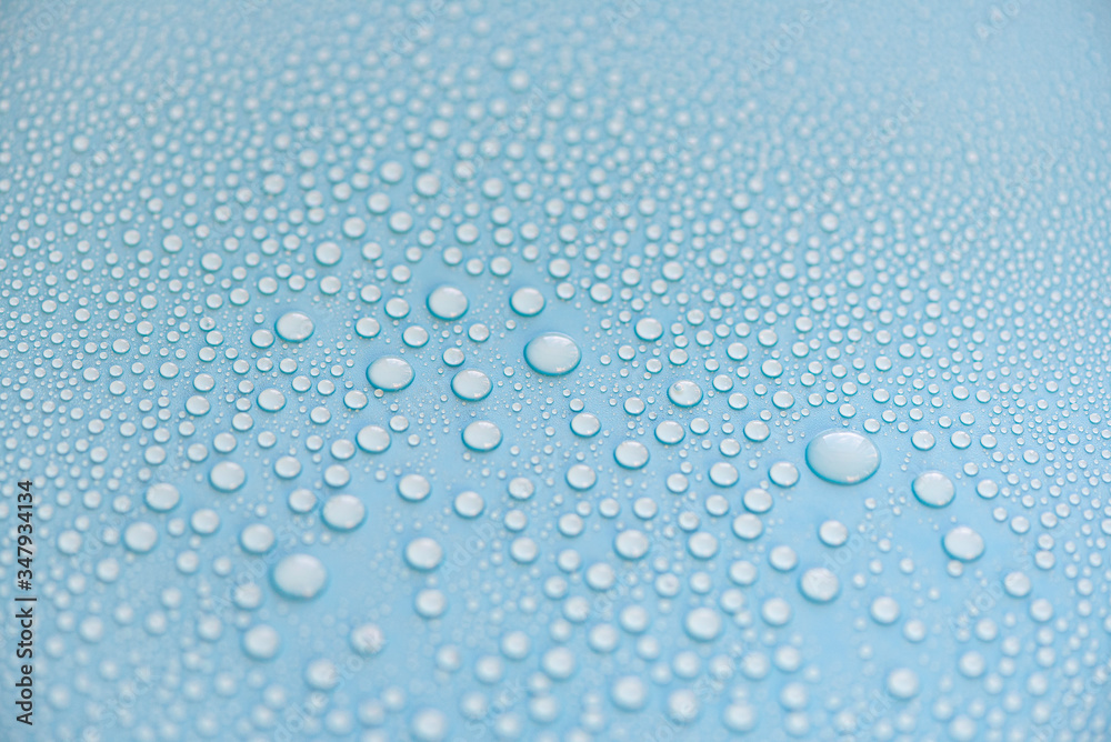 Close-up drops of water on blue surface, raindrops, background or texture 