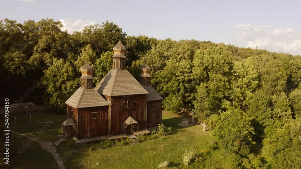 Traditional wooden church in a forest. Aerial dron view. Medieval church in outdoor historical museum.
