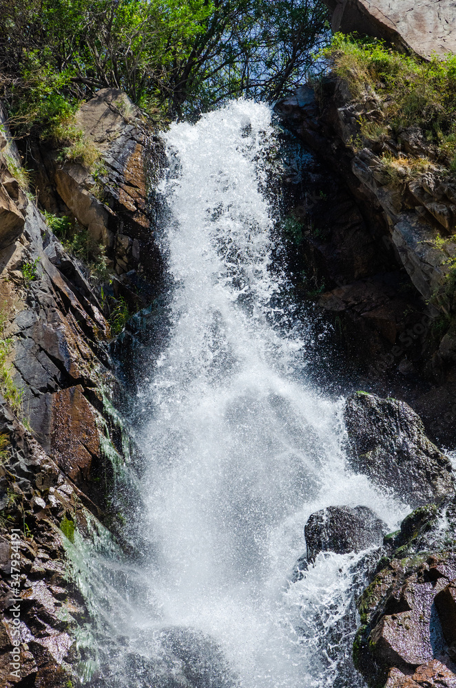 Naklejka premium Rocky mountains waterfall in the afternoon short exposure flash