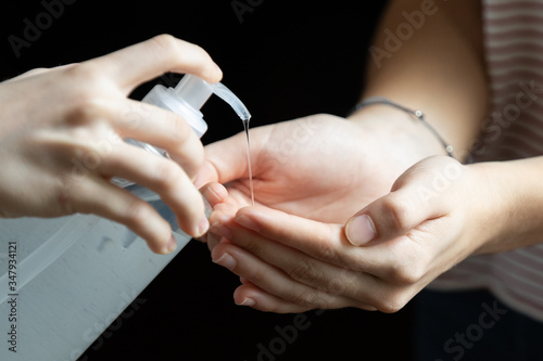 Young woman hands using disinfectant