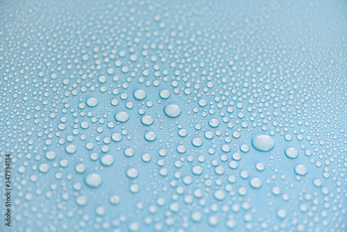 Close-up drops of water on blue surface, raindrops, background or texture 