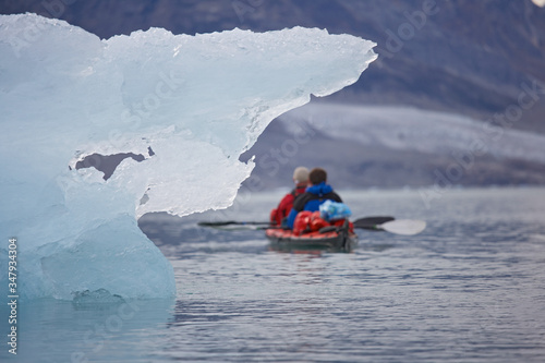 2 men traveling with a sea kayak in Eastern Greenland photo