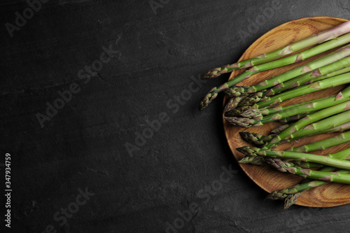 Fresh raw asparagus on black table, top view. Space for text © New Africa