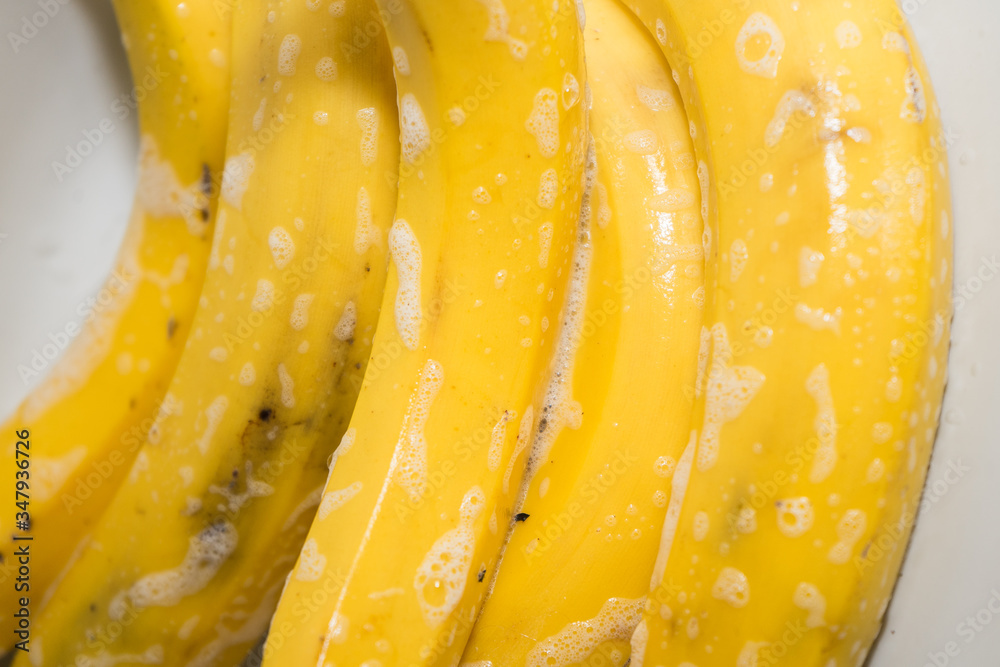Soapy clean bananas in the sink. Washing fruit after purchase for virus prevention Soapy clean bananas in the sink. Washing fruit after purchase for virus prevention