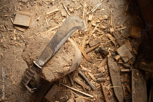 A billhook used to chop some wood. The bill hook is used by farmers and lumberjacks to prune little branches from a bigger branch or a trunk photo