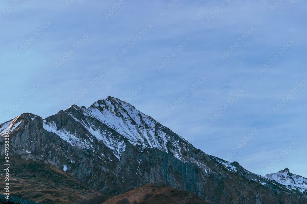 A picturesque landscape view of the rocky snow capped French Pyrenees mountain tops on a winter morning (Arrens-Marsous, Hautes-Pyrenees, Occitanie, France)