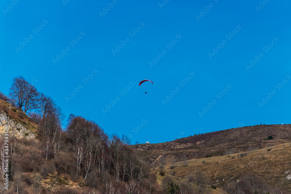 A minimalist shot of a small yellow hot air balloon floating high in the clear blue sky in winter A minimalist shot of a small yellow hot air balloon floating high in the clear blue sky in winter
