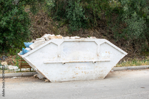 Loaded skip bin with waste on a road. photo