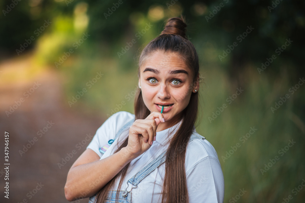 Girl with a candy on a stick on the nature