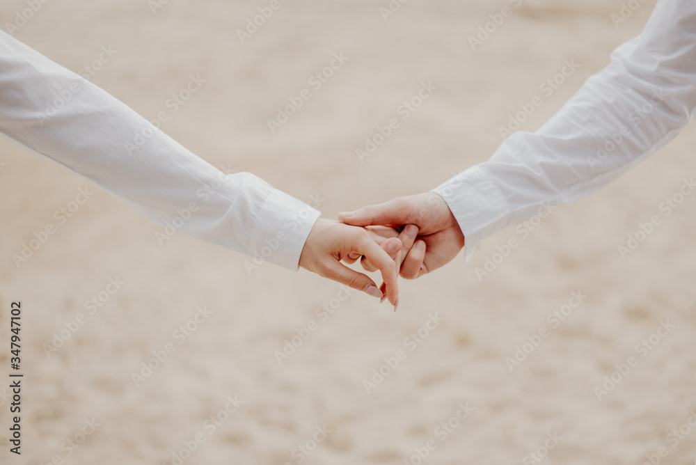 Lovers boy and girl in white clothes hold hands
