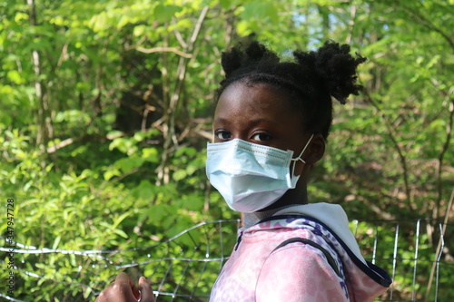 Black Girl wearing surgical mask in woods background