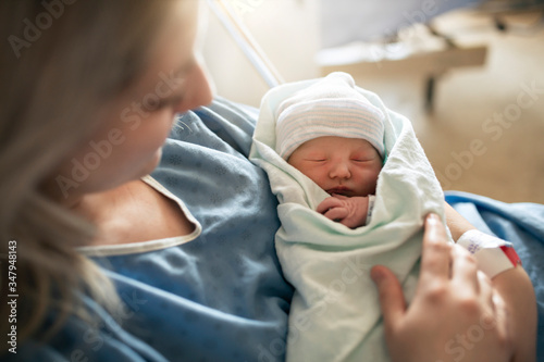 Mother with her newborn baby at the hospital a day after a natural birth labor photo