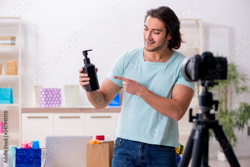 Young male shopaholic recording video for his blog