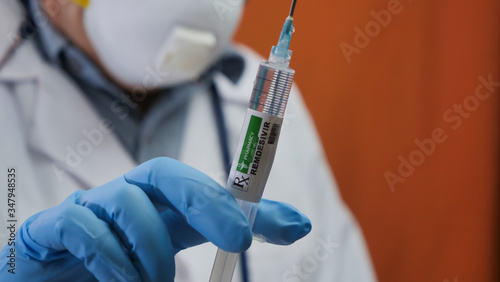 Doctor with a syringe filled with the drug remdesivir photo