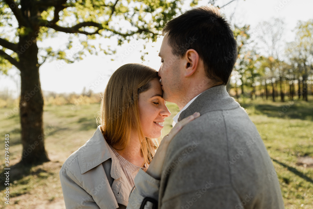 husband tenderly kisses his wife on the forehead,pregnant wife hugs husband husband tenderly kisses his wife on the forehead,pregnant wife hugs husband