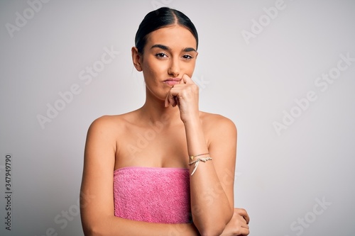 Obraz na płótnie Young beautiful brunette woman wearing towel after shower over isolated white background thinking looking tired and bored with depression problems with crossed arms