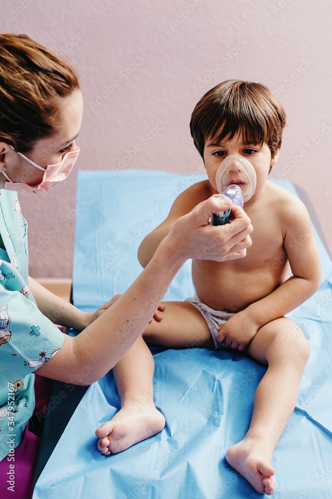Sick boy getting inhalation treatment in clinic Sick boy getting inhalation treatment in clinic