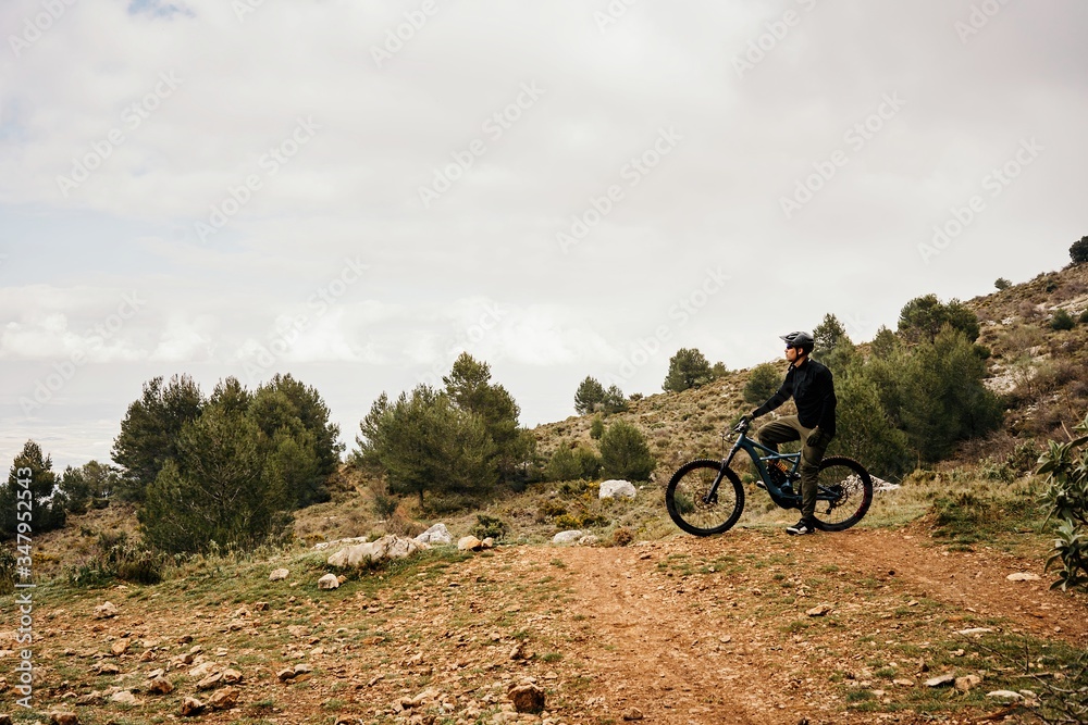 Cyclist riding bike on rocky path in forest Cyclist riding bike on rocky path in forest