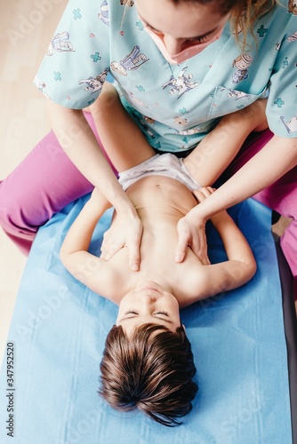 Nurse examining little boy in clinic photo