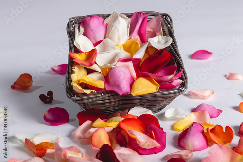 Panier de pétales de roses rose, rouge, orange et blanc.