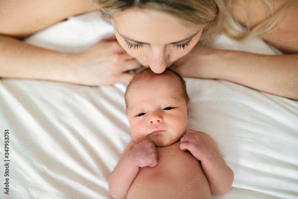 A woman with a newborn baby in bed A woman with a newborn baby in bed
