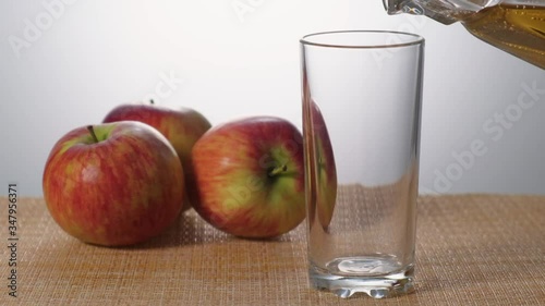 Apple juice is poured to half a glass slow motion