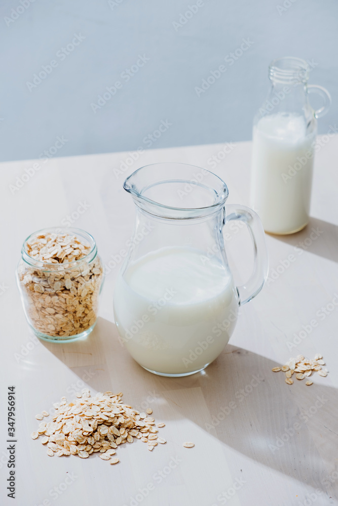 Jar of milk and oatmeal flakes on table Jar of milk and oatmeal flakes on table