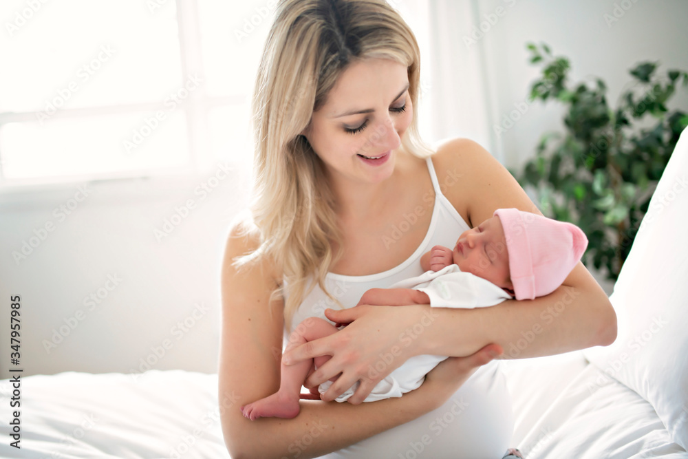A woman with a newborn baby in bed A woman with a newborn baby in bed