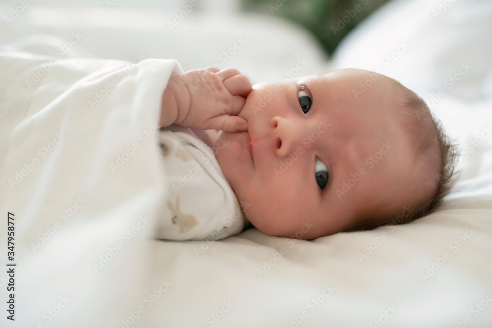 A Sweet newborn baby girl sleeping in white bed A Sweet newborn baby girl sleeping in white bed