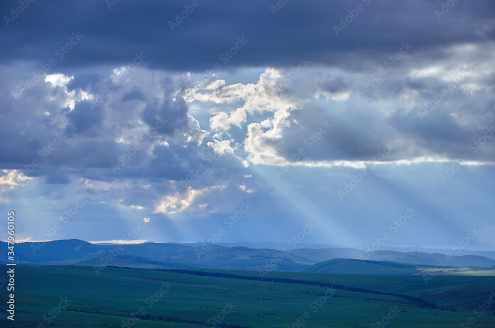 Rain clouds over distant hills at sunset. Zabaykalsky Krai. Russia.