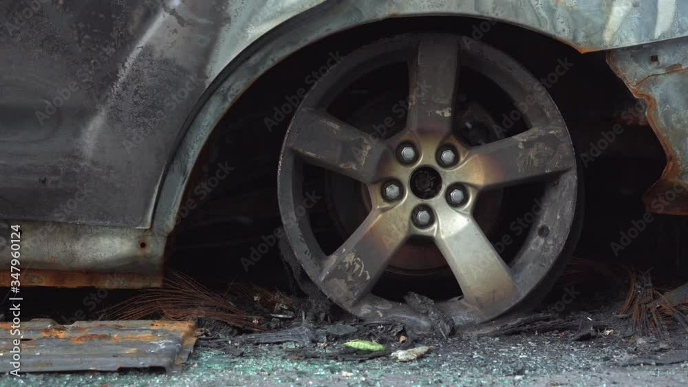 Arson of a car by vandals. Burnt car parked on a city street. Car insurance. Guarded parking of vehicles. Damaged car close-up Arson of a car by vandals. Burnt car parked on a city street. Car insurance. Guarded parking of vehicles. Damaged car close-up